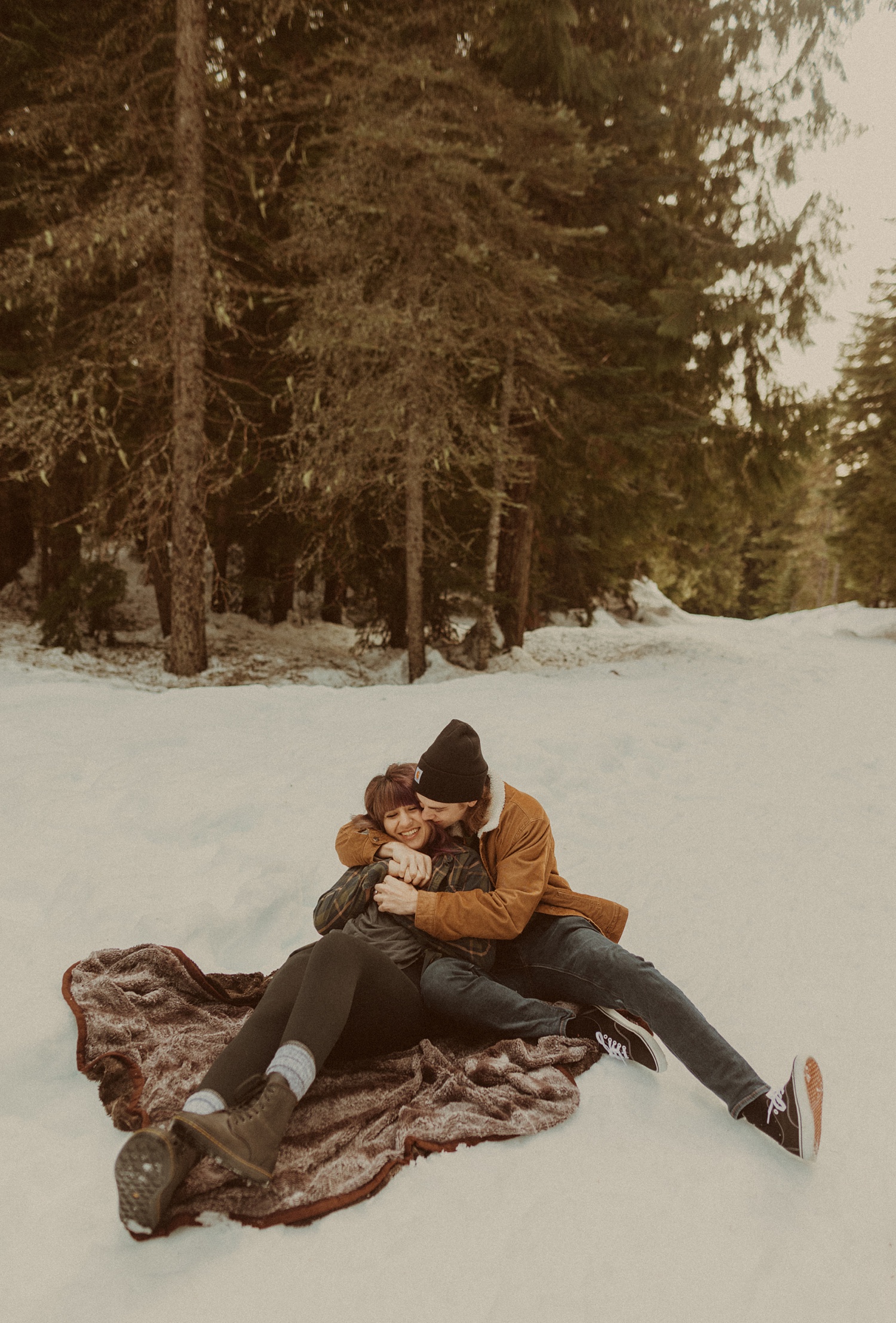 A couple snuggling in the snow during their mt hood engagement photos